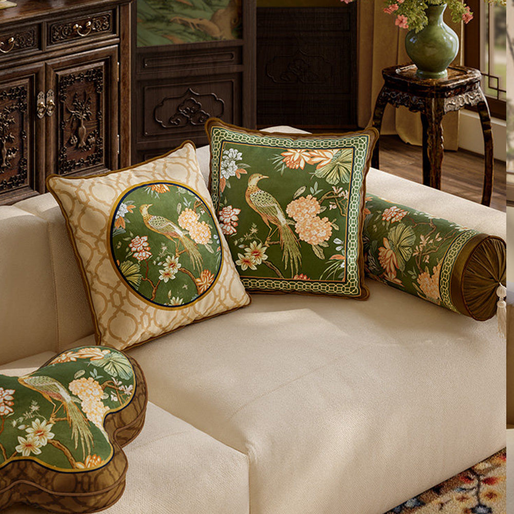 Aviary green and cream botanical bird pillow covers layered on a sofa