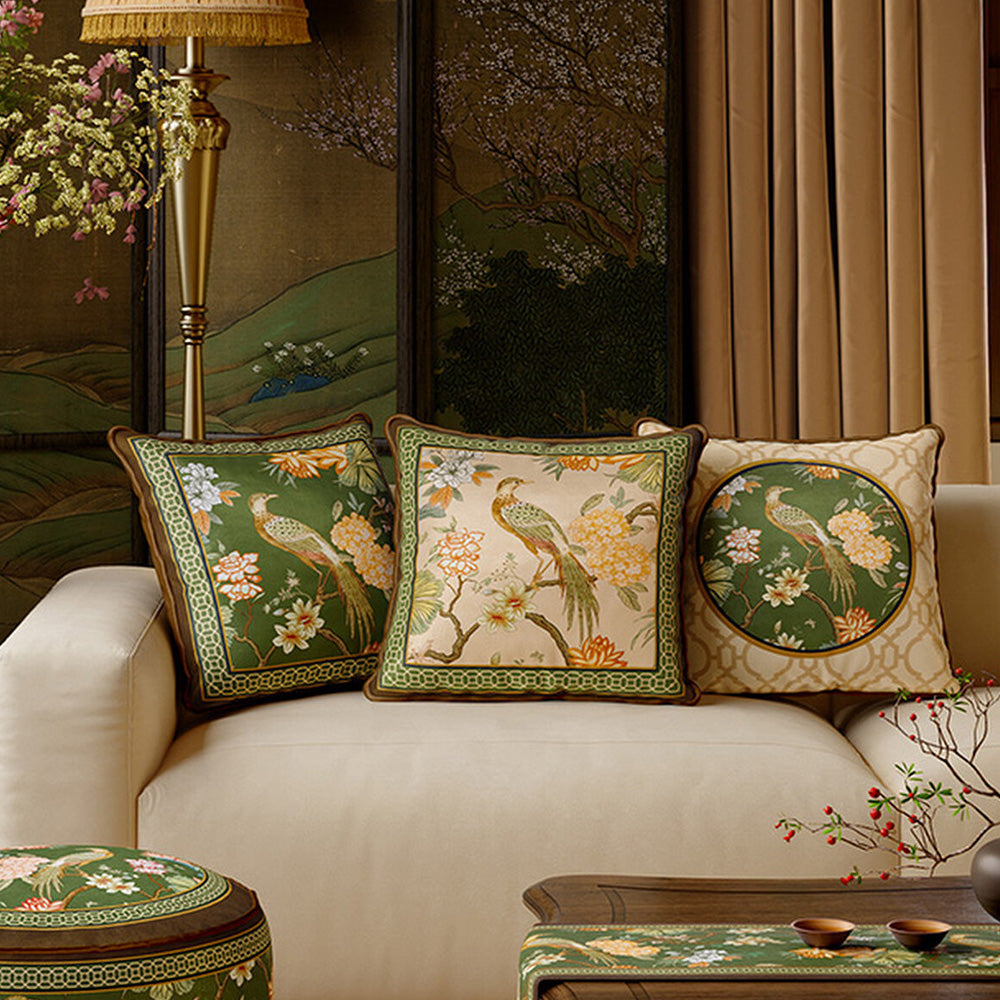 Three Aviary botanical bird pillow cover designs arranged on a cream sofa