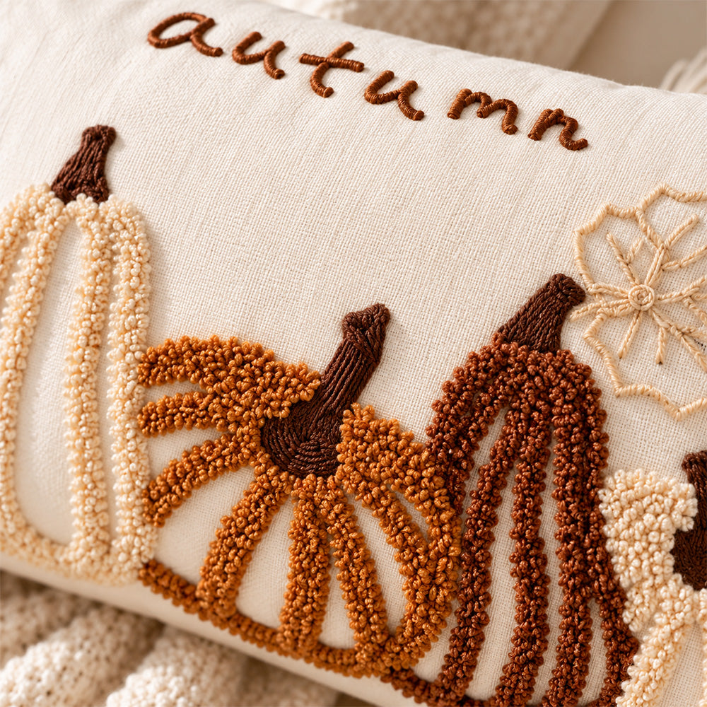 Close-up of raised rust and ivory pumpkin embroidery with autumn lettering on cream fabric