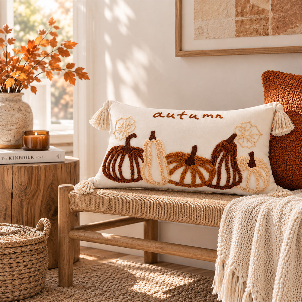 Harvestline pumpkin lumbar pillow cover displayed on a woven wood bench in an autumn setting