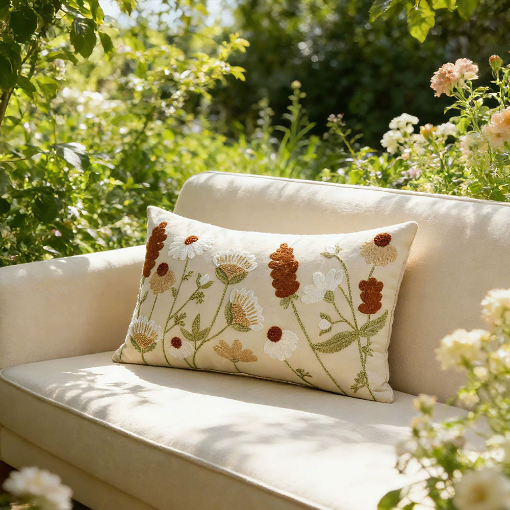 Embroidered wildflower lumbar pillow cover on a neutral bed