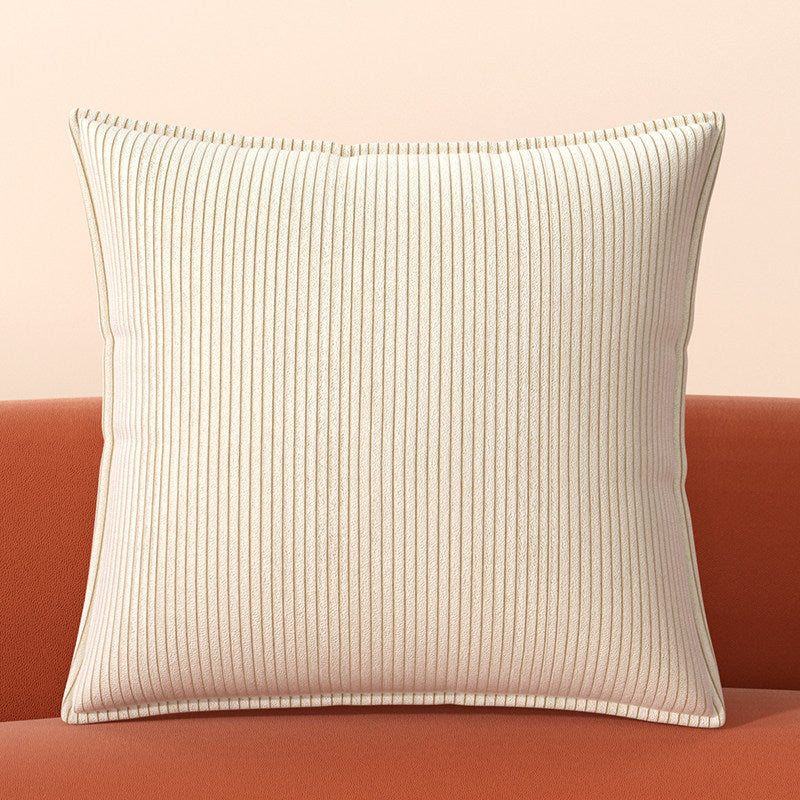 Cream Ridge corduroy pillow cover with vertical ribbed texture on a rust sofa