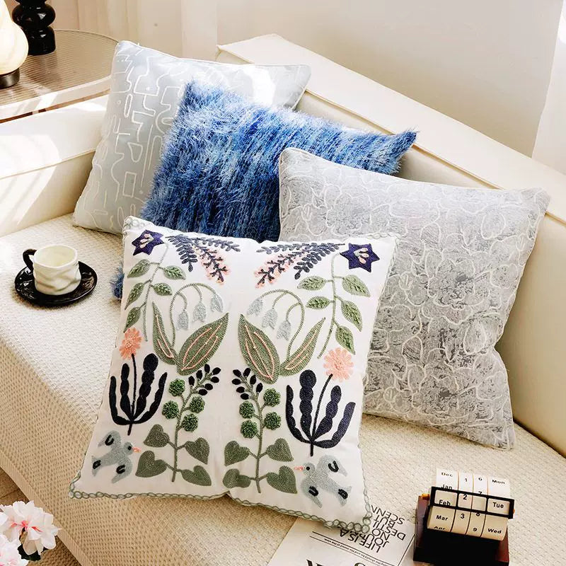 decorative embroidered pillow cover with botanical leaves and bird accents