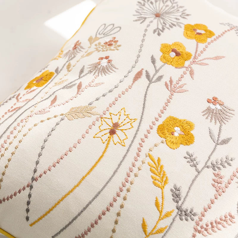 Close-up of embroidered wildflower pillow cover with botanical floral stitching