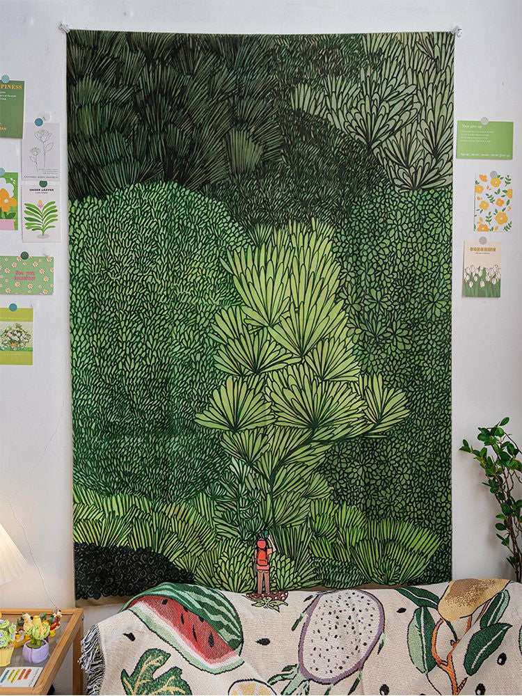 Sylvan green forest wall tapestry styled with botanical prints in a bedroom