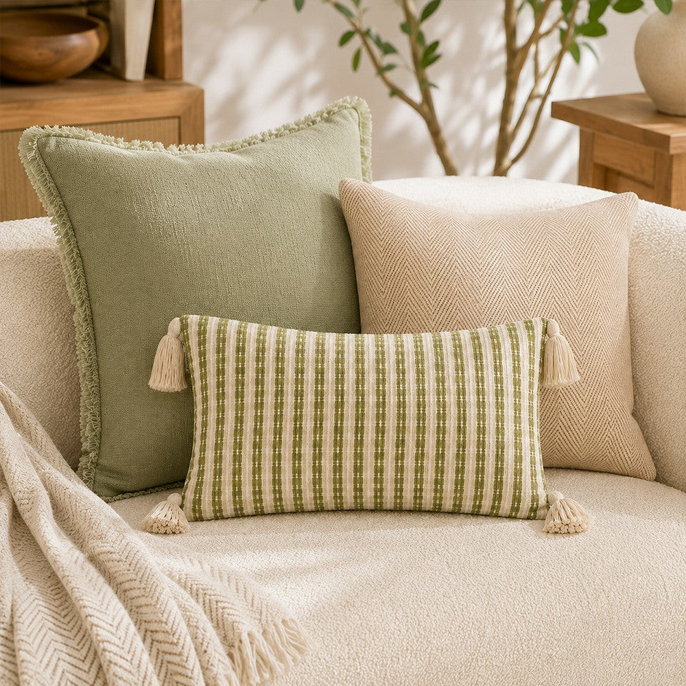 Meadowline green striped lumbar pillow cover centered on a sofa with coordinating neutral cushions