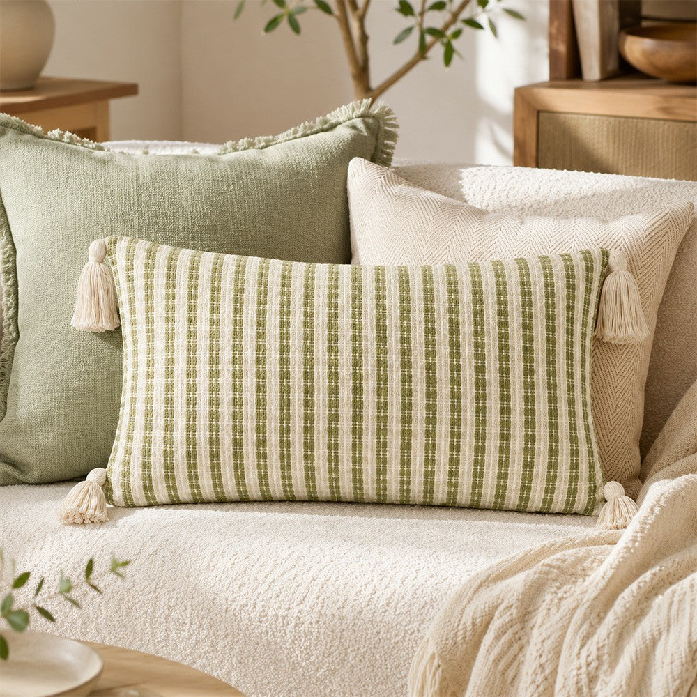 Meadowline green striped lumbar pillow cover layered with neutral cushions on a cream sofa
