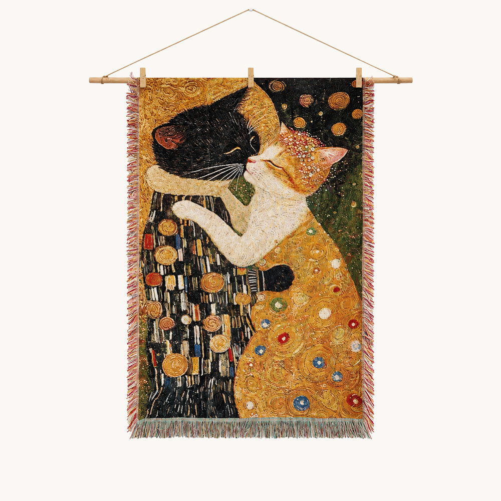Art-inspired woven wall tapestry featuring two cats in an affectionate pose, with rich gold, black, green, and cream tones, decorative circular details, and fringed edges.
