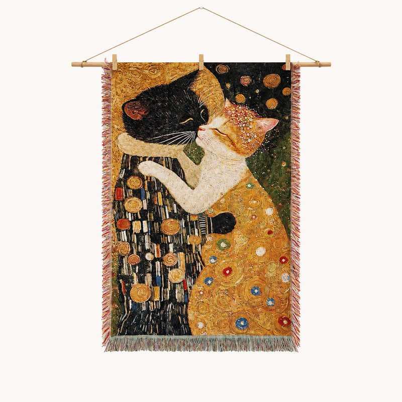 Art-inspired woven wall tapestry featuring two cats in an affectionate pose, with rich gold, black, green, and cream tones, decorative circular details, and fringed edges.