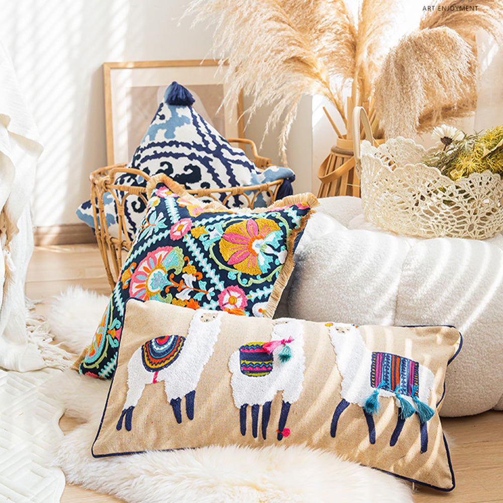 Embroidered boho floral pillow cover displayed on a woven basket beside pampas grass and neutral home décor.