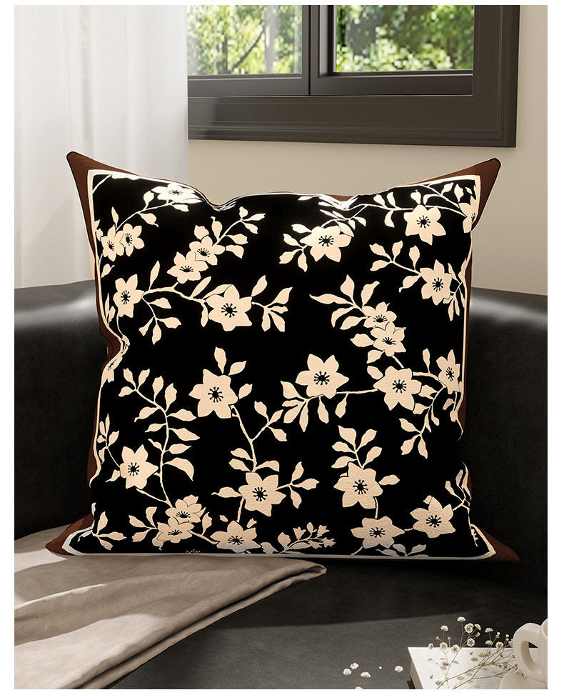 Inkstone black floral velvet pillow cover styled on a dark sofa