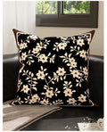 Inkstone black floral velvet pillow cover styled on a dark sofa