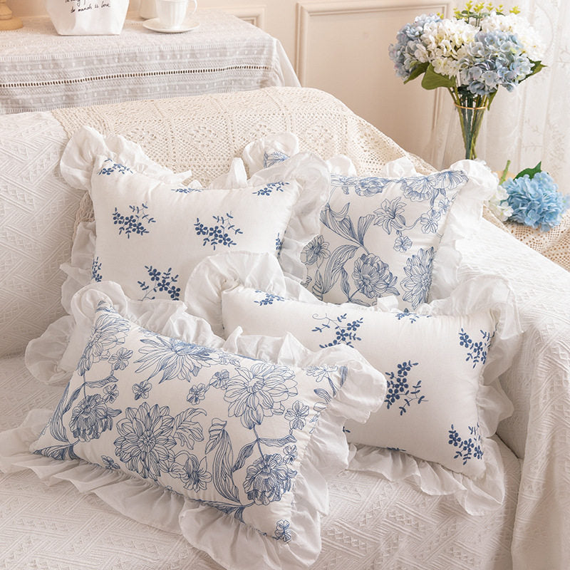 Four Porcelain blue and white cotton pillow cover designs layered on a sofa