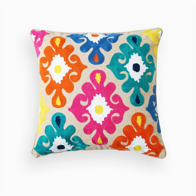 Beige embroidered boho pillow cover featuring colorful geometric floral motifs on a neutral linen-look background.