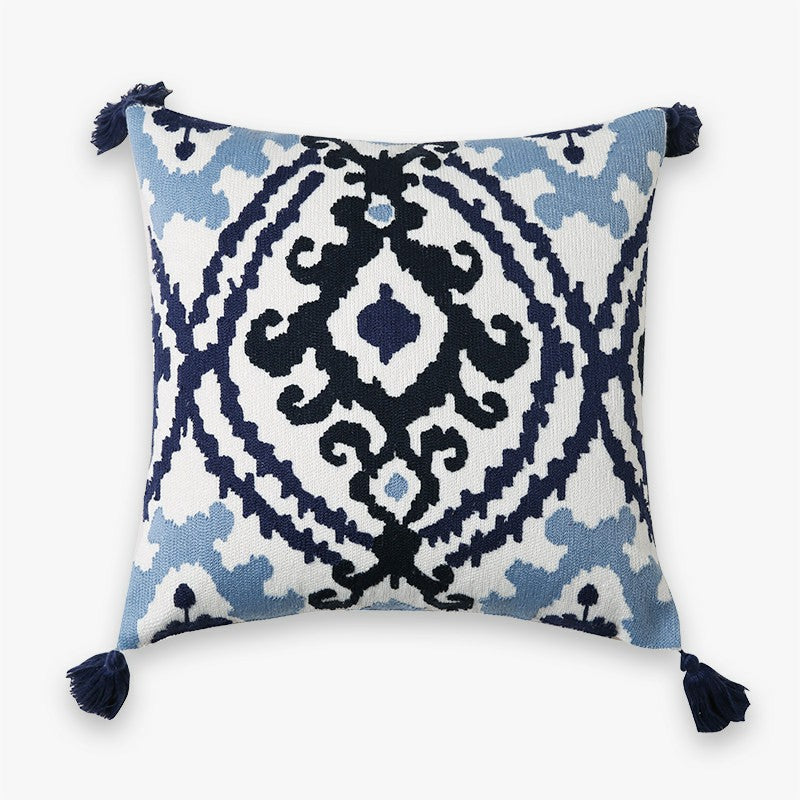 Blue and white embroidered decorative pillow cover with navy tassels and traditional bohemian pattern.