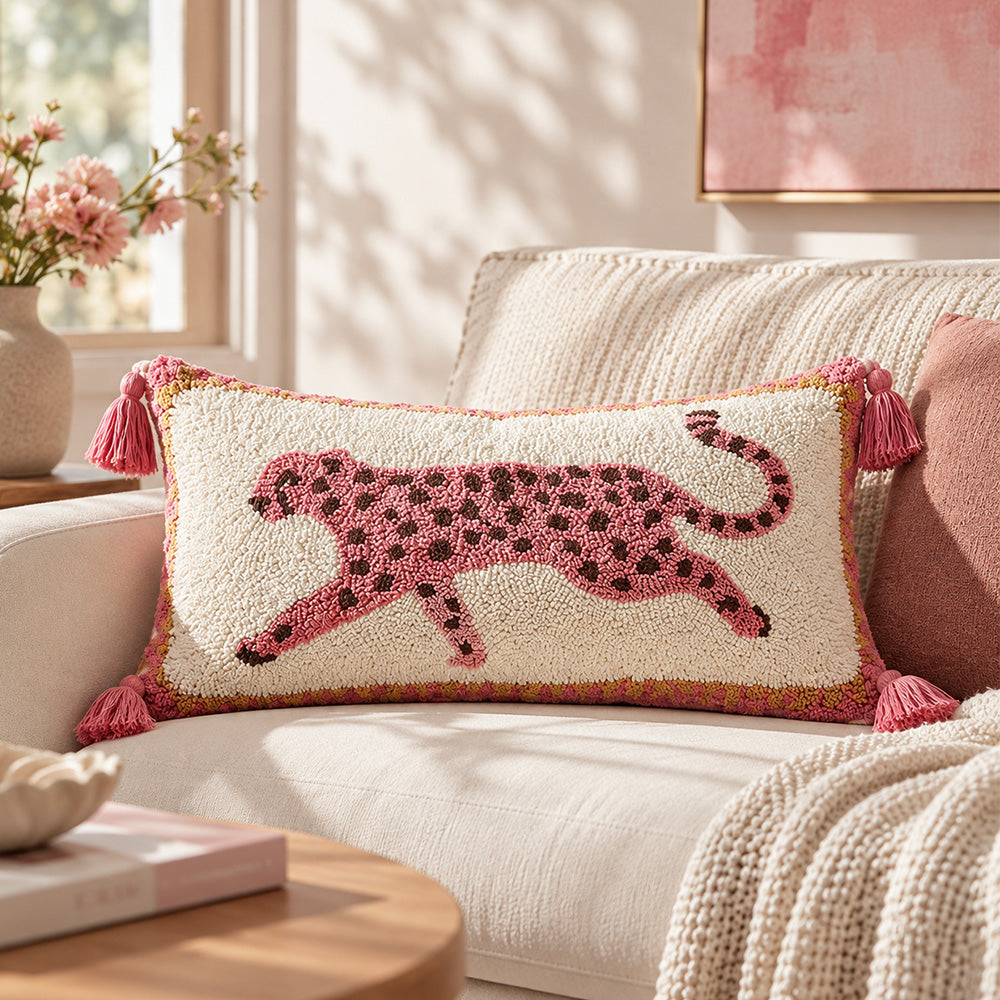 Pink tufted leopard lumbar pillow cover on a cream sofa beneath soft pink wall art
