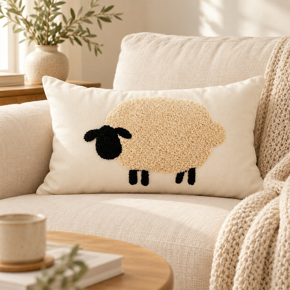 Sheep lumbar pillow styled on a soft beige sofa with a cozy knit throw.