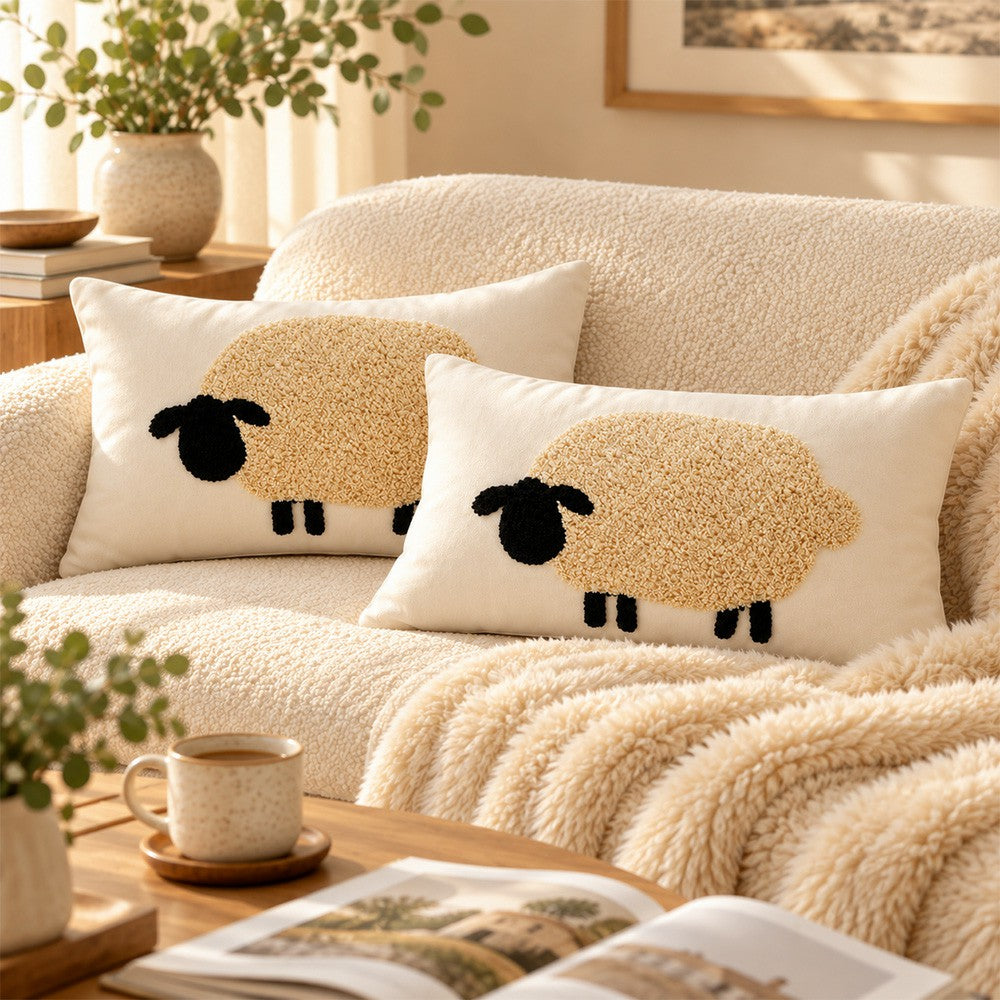 Cream Pasture lumbar pillow cover with raised sheep appliqués on a beige couch