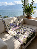 Floribunda purple botanical cotton throw blanket draped over a sofa by a lake view