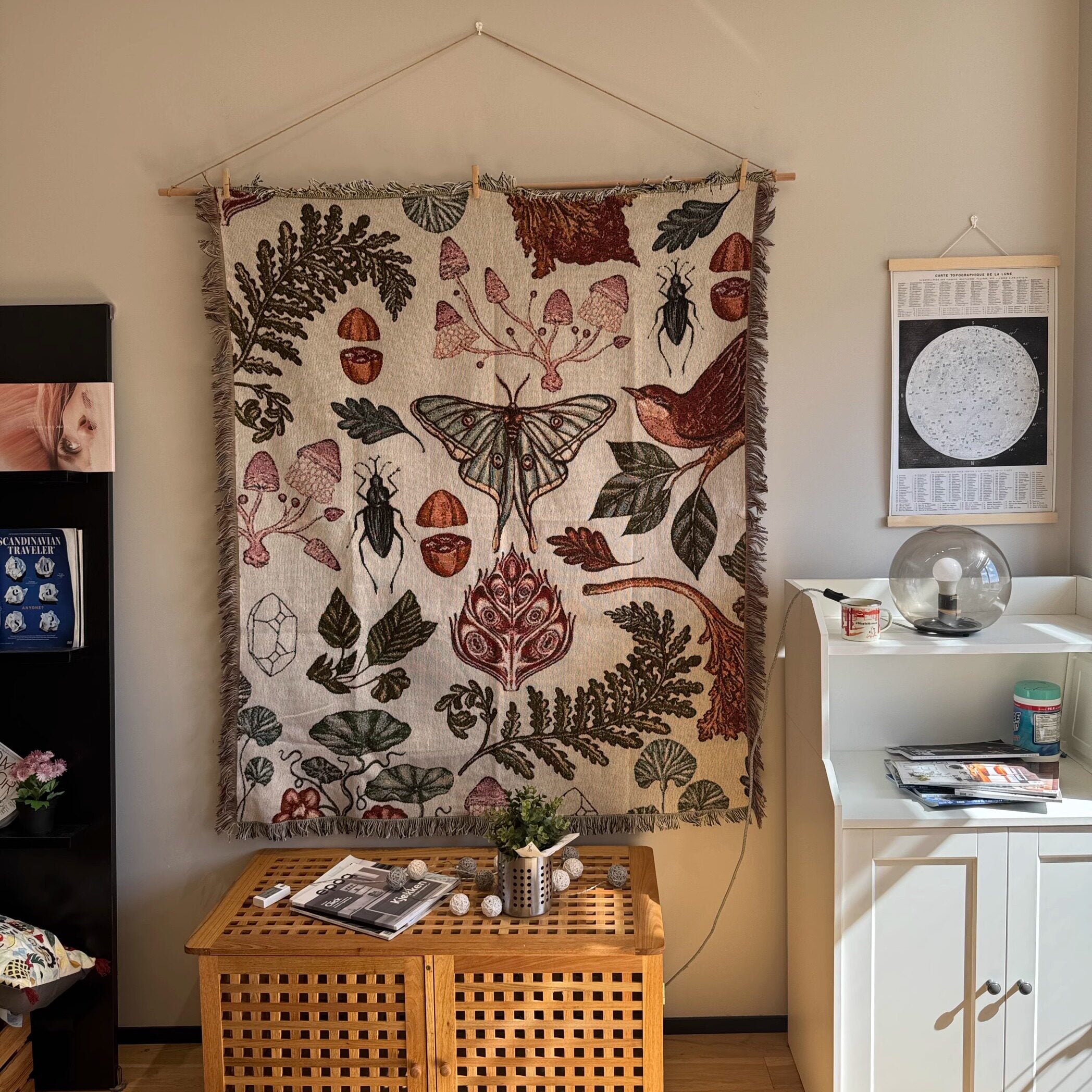 Mushroom Grove cream moth and mushroom tapestry hanging above a wood cabinet