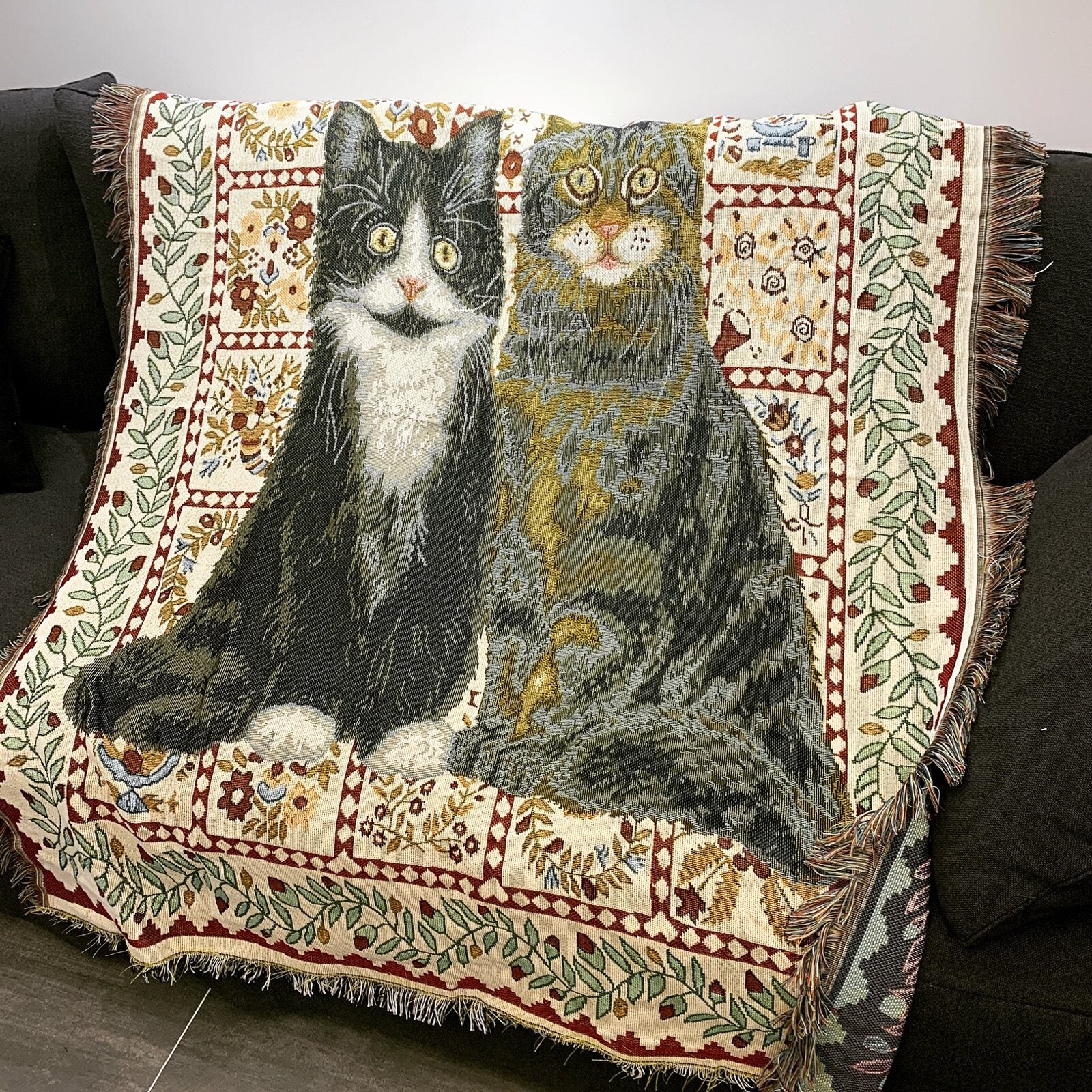 Whisker cat throw blanket draped over a black sofa